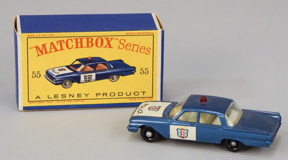 Blue toy police patrol car with red roof light and white decals beside a Matchbox “Series” box labeled “A. Lesney Product 55.”