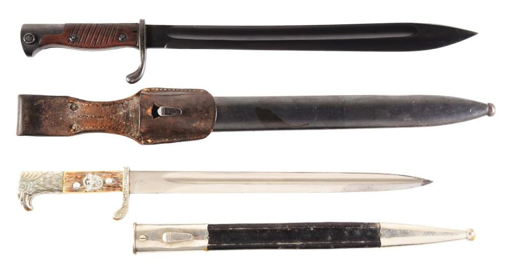 Two bayonets shown side by side, each with a metal blade and dark grips with leather scabbards.