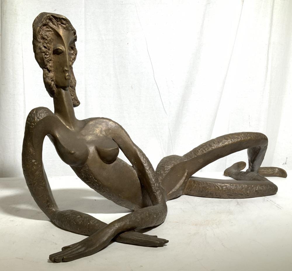 Bronze-colored abstract female nude sculpture reclining on its side with head and torso lifted, arms resting near the body.