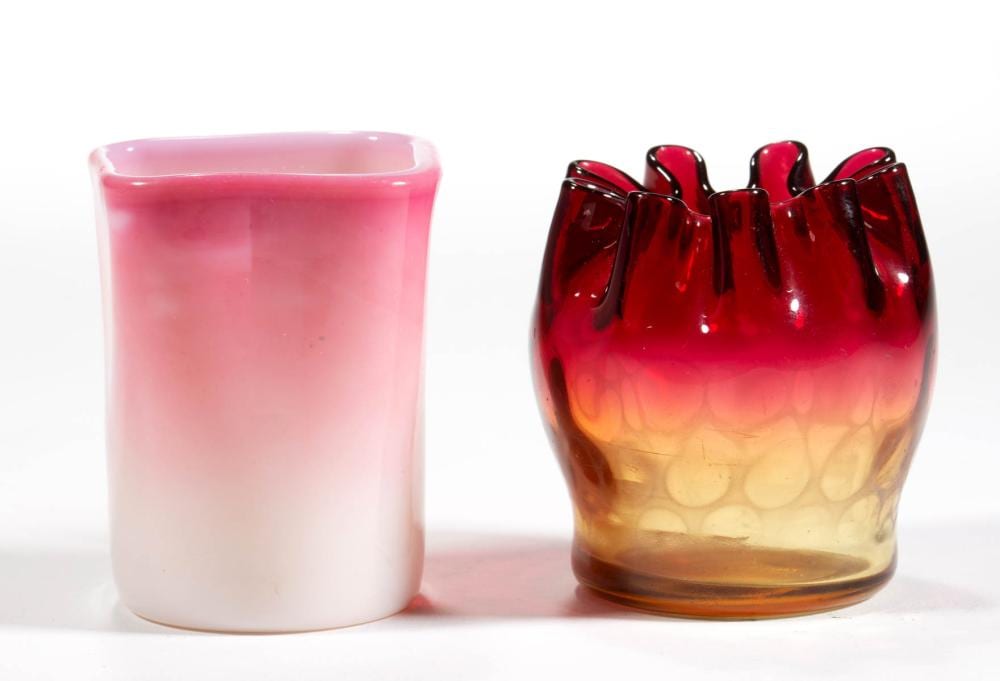 Two vintage-style glass tumblers or holders in pink and amber-red, photographed side by side on a white background.
