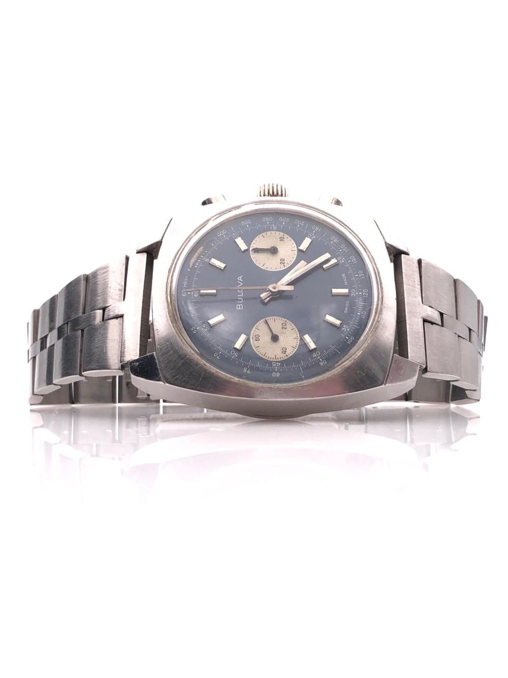 Close-up of a blue dial vintage chronograph wristwatch with silver metal bracelet and two subdials, photographed on a white background.
