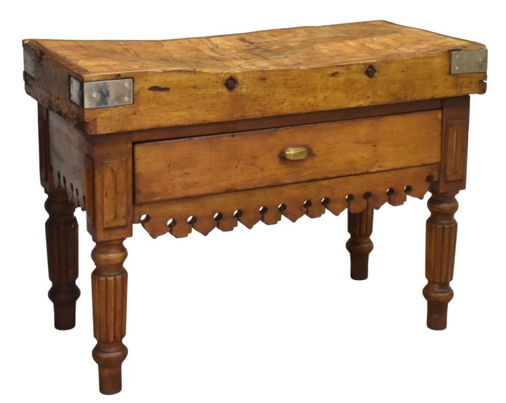 Antique-style wooden butcher block table with a hinged drawer and metal accents on the front rail.