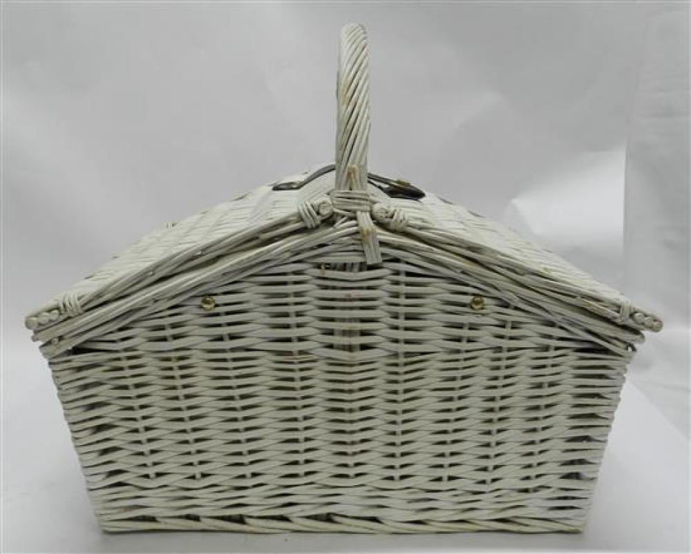 White woven wicker picnic basket with a front lattice pattern and a looped handle, photographed on a plain background.