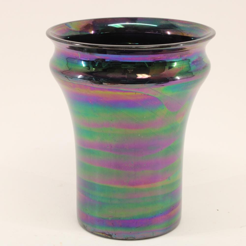 Colorful iridescent glass vase with dark interior, rounded rim, and wavy horizontal rainbow bands.