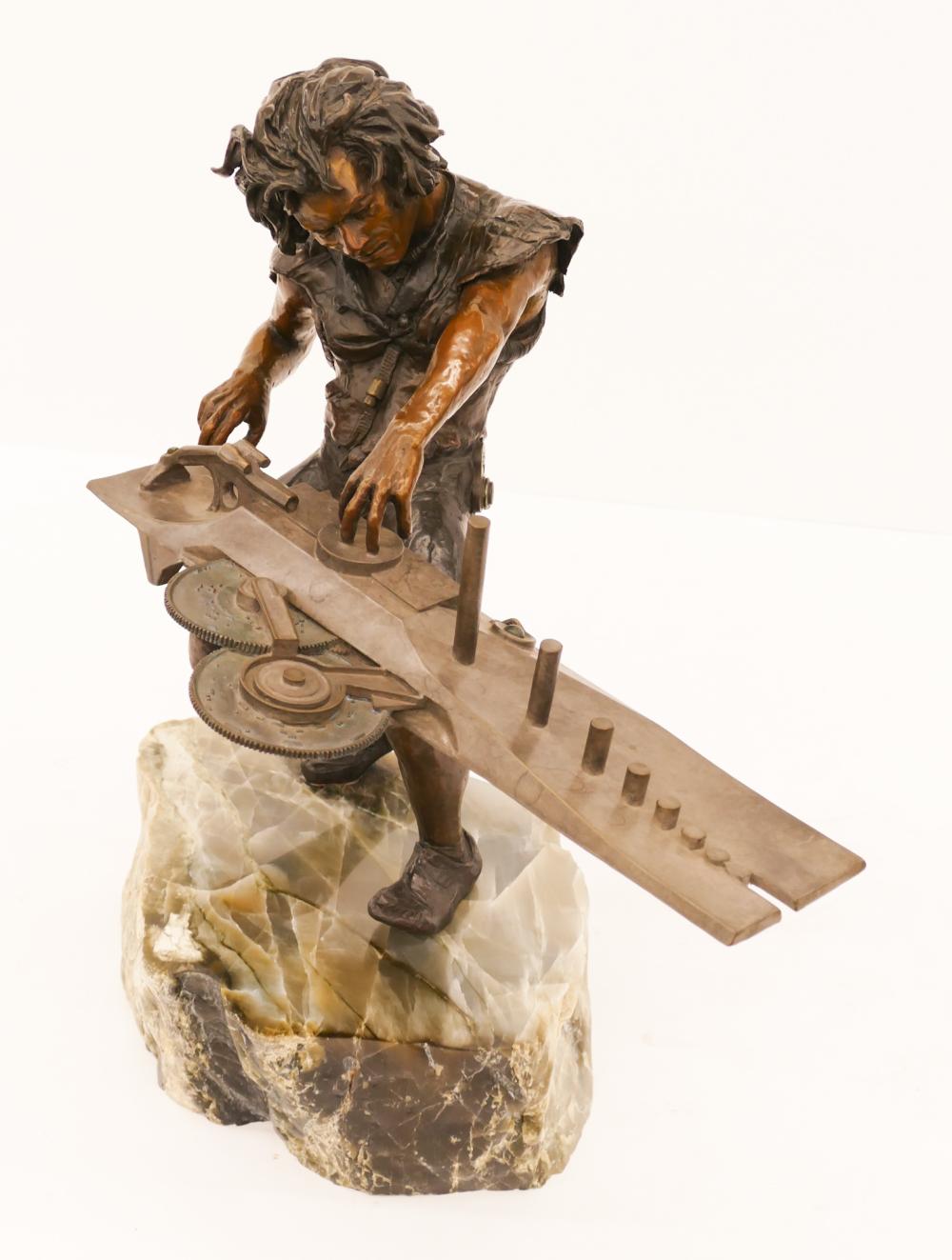Bronze sculpture of a man standing and playing a long multi-string instrument on a marble base.