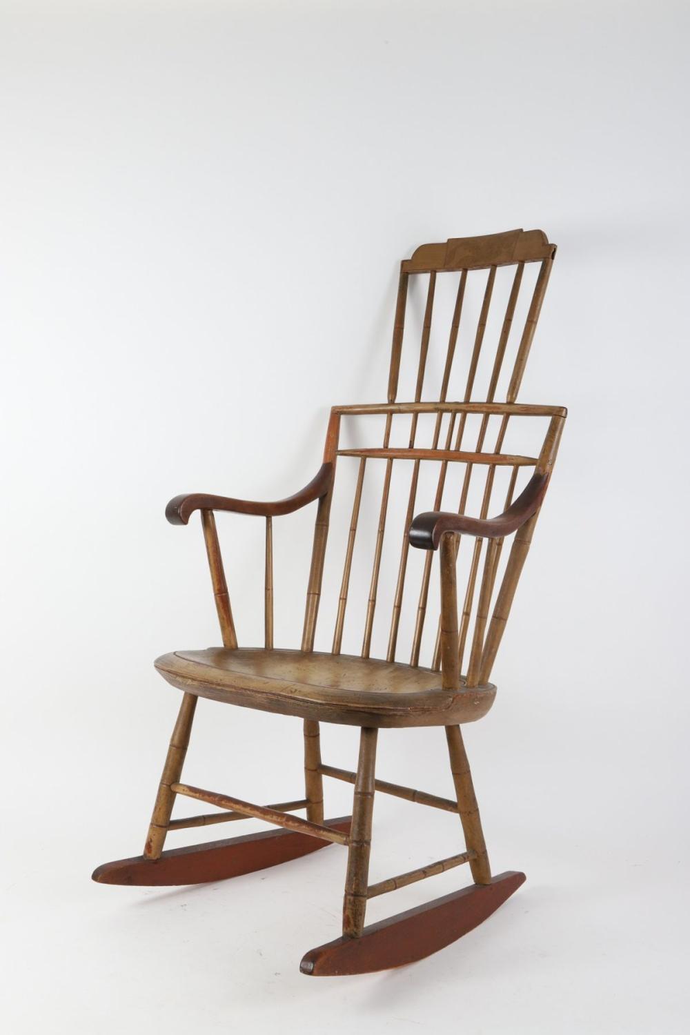 Wood rocking chair with a slatted comb backrest, curved armrests, and a curved wooden seat on curved rockers.