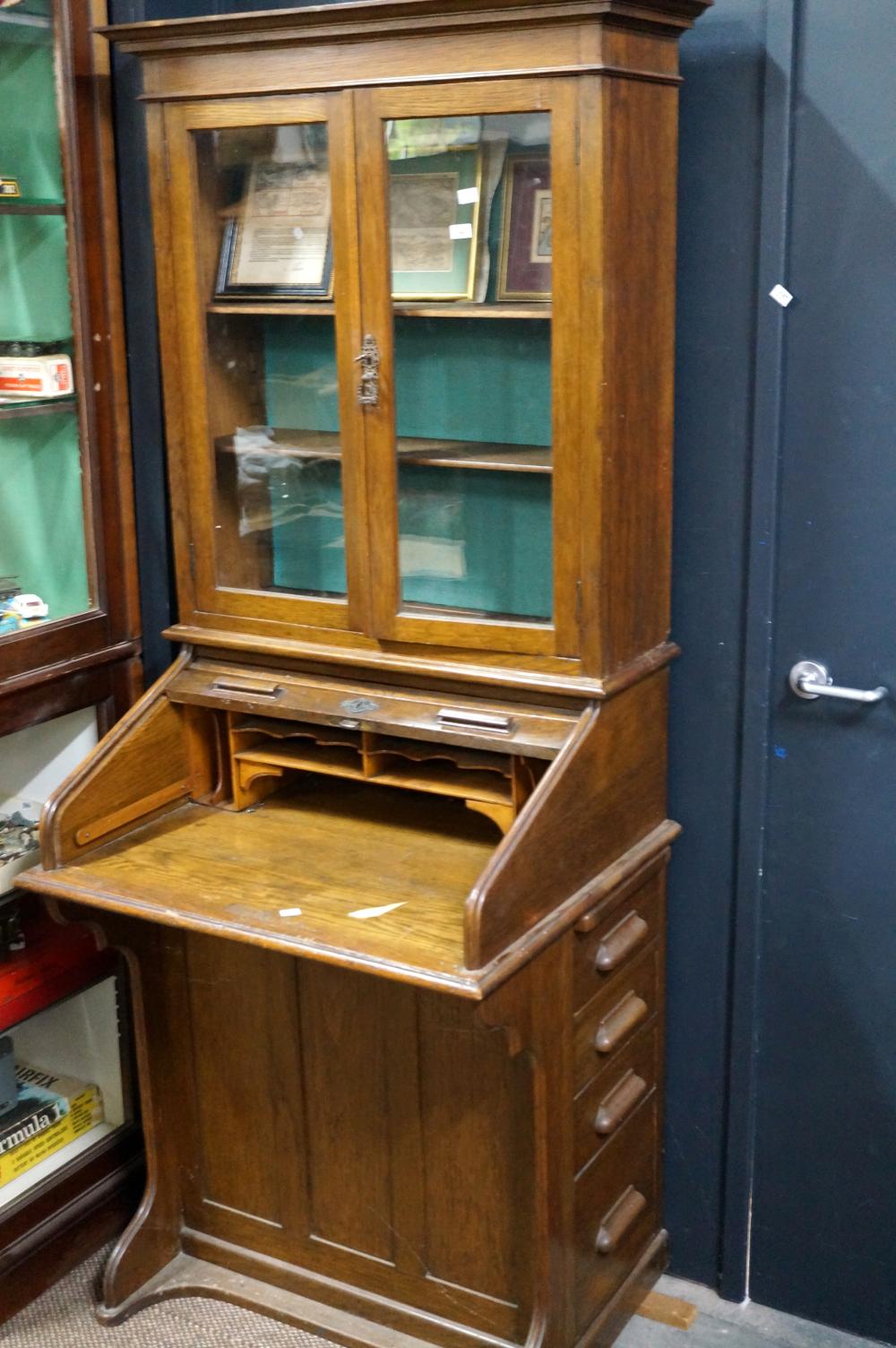Unusual antique oak roll front secretaire bookcase of small proportions with bank of 4 drawers on right hand side, 73 w x 1`85 cm h sold by Woodlands Auctions, lot 348 — auction record photograph