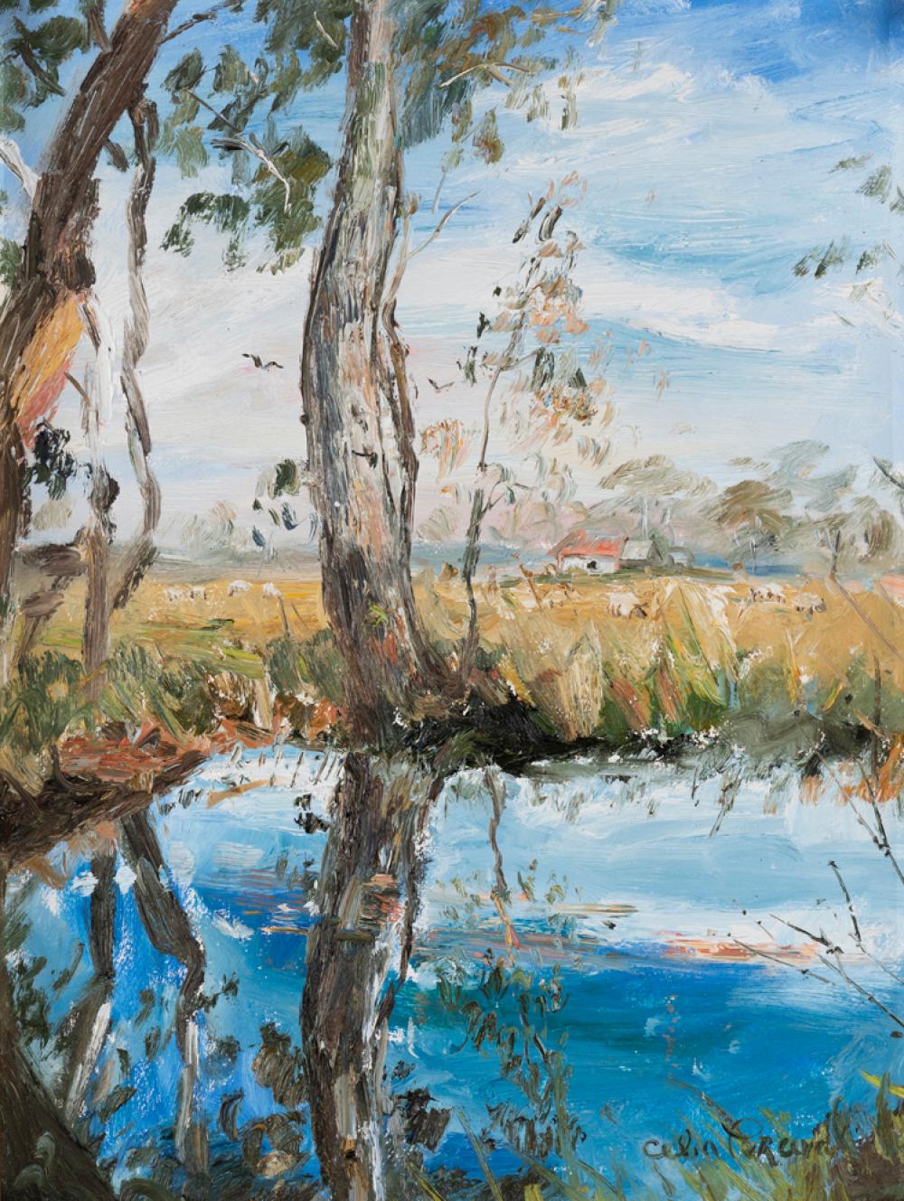 Landscape painting of a blue river or lake with tall tree trunks in the foreground, a small red-roofed house in the distance, and a blue sky.