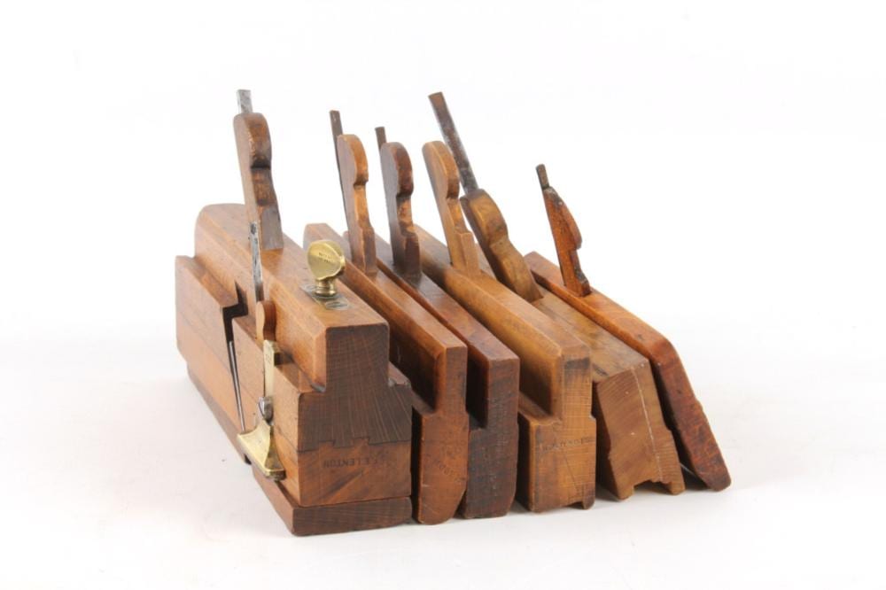 Collection of six wooden hand planes tools grouped together, showing metal blades and handles on a white background.
