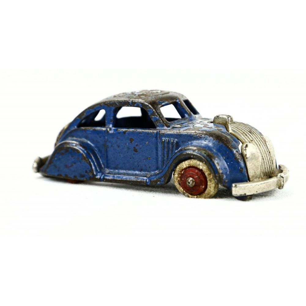 Small cast-iron toy car with a blue body, ribbed silver front fender, and red wheel hub detail.