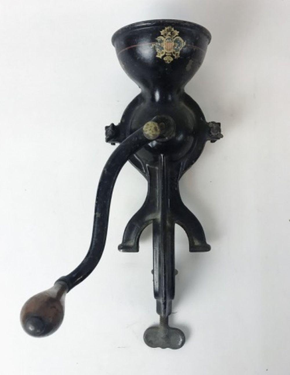 Black metal hand coffee grinder with a rounded top funnel and a curved crank handle, shown against a plain light background.