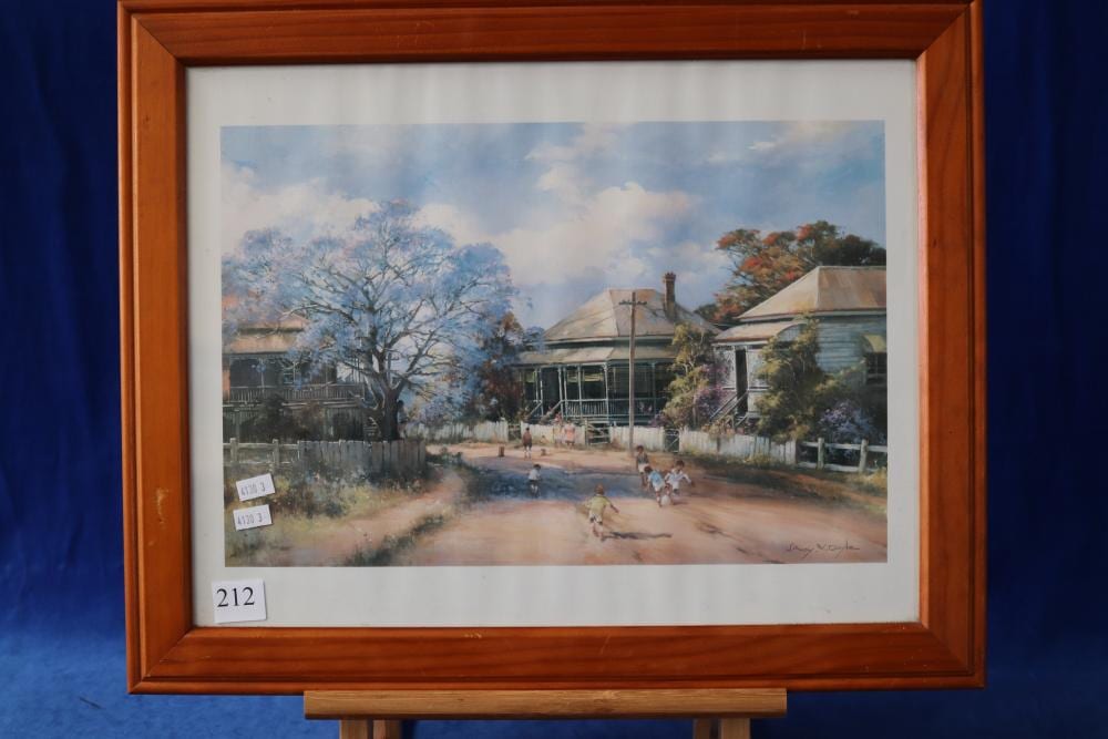 Framed landscape print showing a rural street with trees in autumn colors and small buildings under a partly cloudy sky.