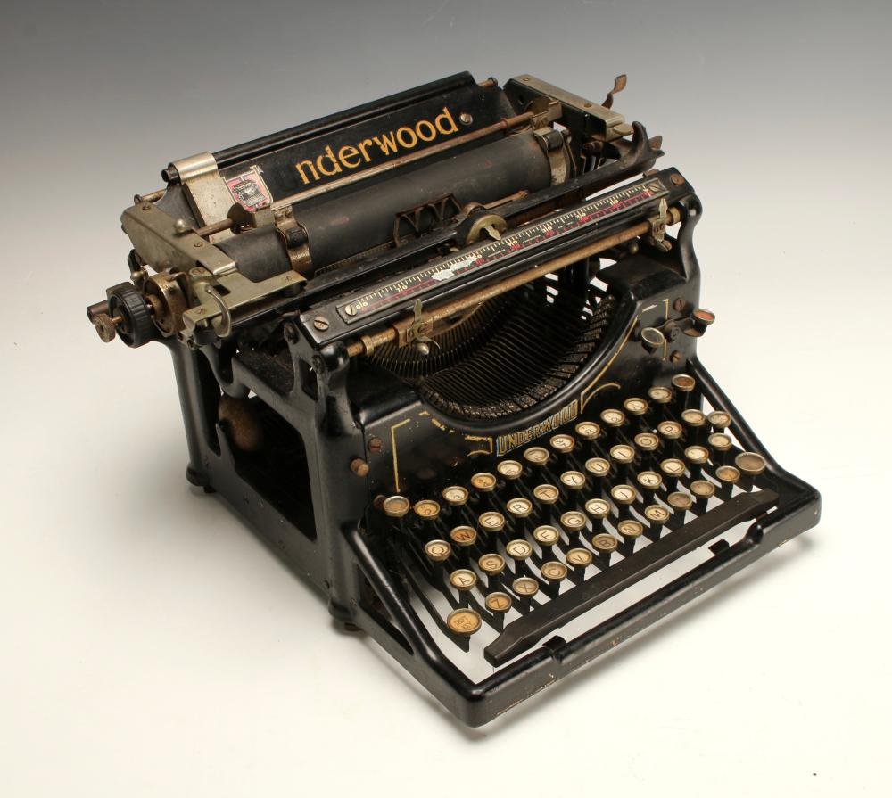 Vintage Underwood typewriter with black body, keys and carriage visible, and paper platen and typebars in view.
