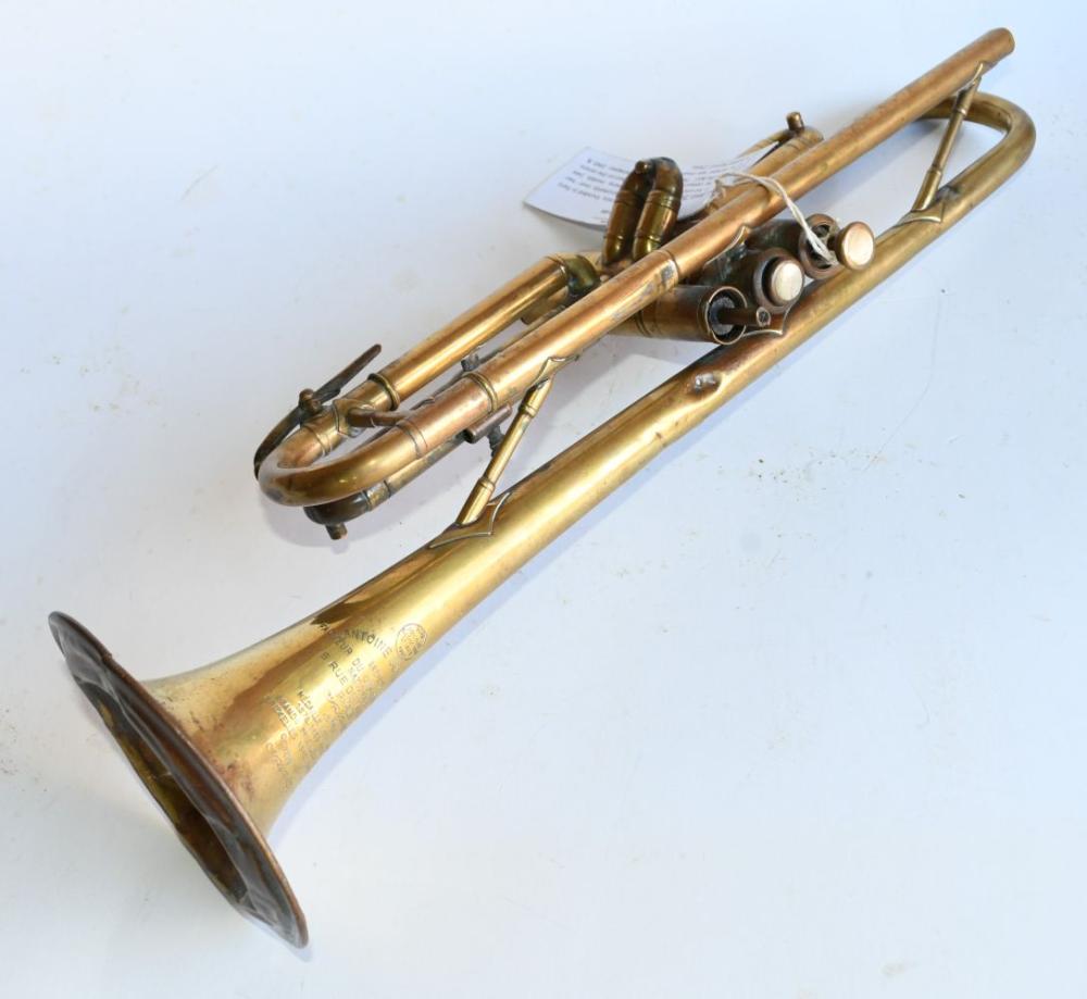Vintage brass trumpet with three piston valves, shown on a light background.