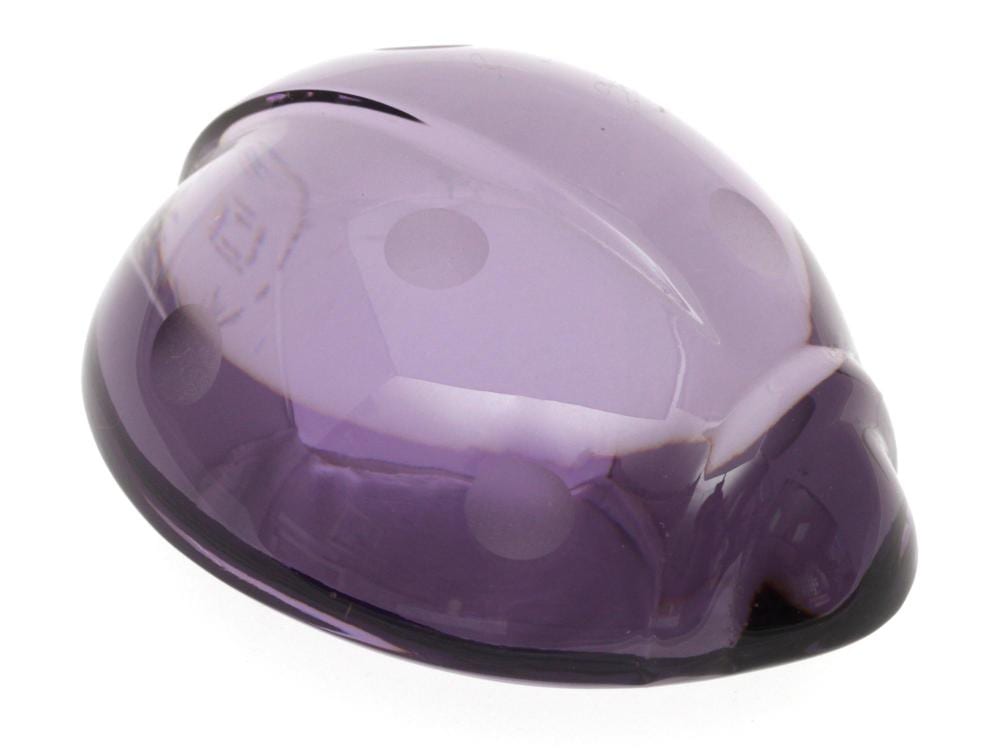 Purple glass ladybug-shaped paperweight with faceted body and dark base, photographed on a white background.