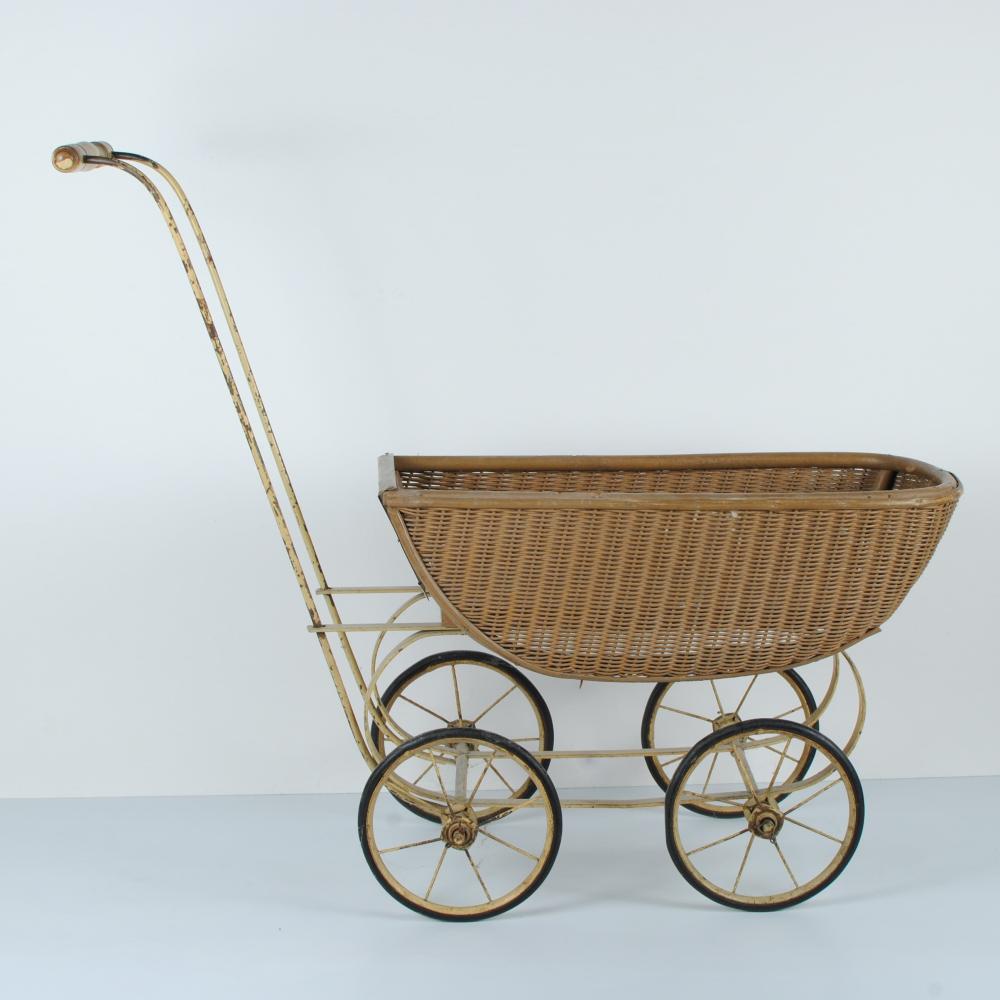 Vintage doll carriage stroller with a wicker basket body and four wire-spoke wheels.