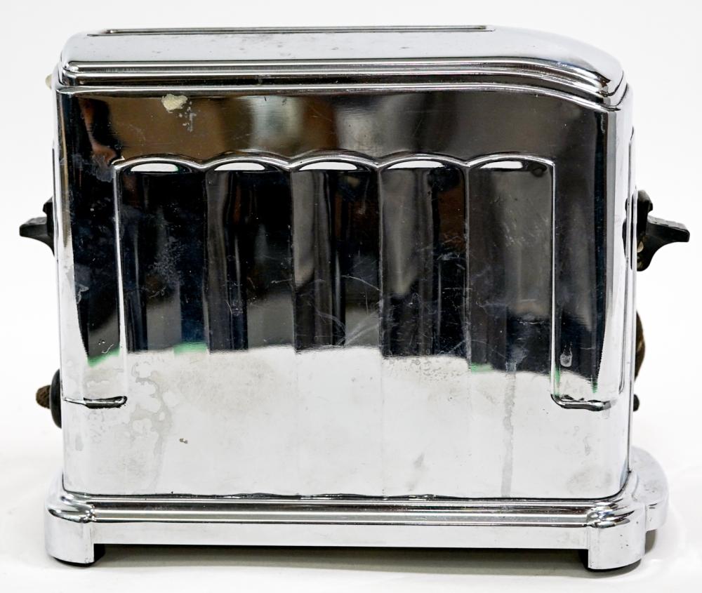 Close-up of a vintage stainless-steel electric toaster with chrome sides and top, photographed front-on against a white background.