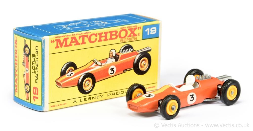 Matchbox die-cast racing car toy in orange with a driver figure, shown beside its blue and yellow “Matchbox Series” box labeled 19.