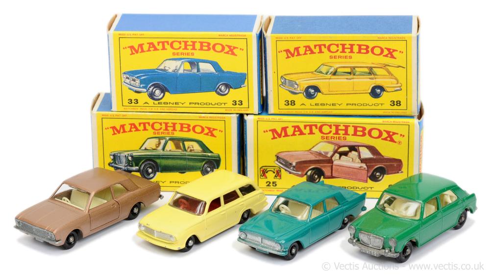 Four Matchbox toy car models in front of two open Matchbox Series boxes with illustrated classic British cars.