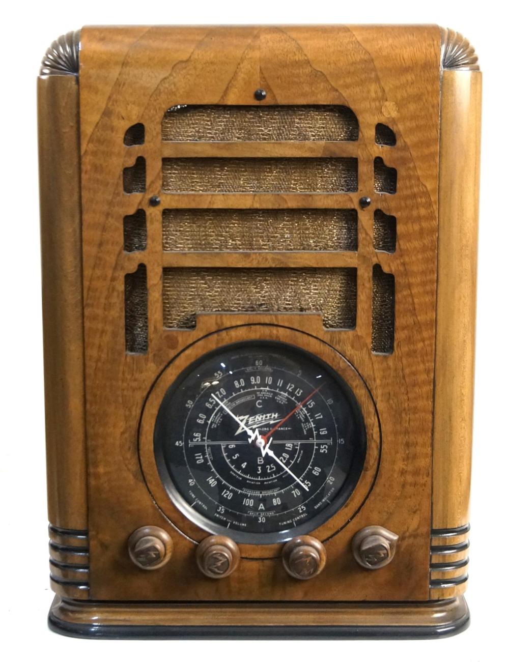 Front view of a vintage wooden Zenith tombstone-style tube radio with a round tuning dial and grille openings.