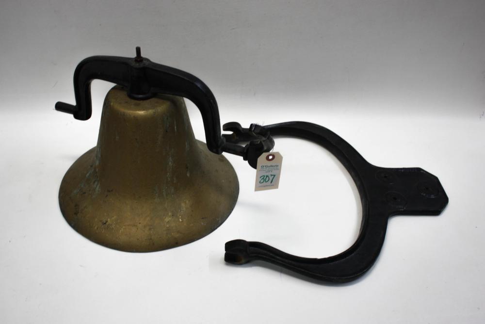 Vintage metal school bell with a brownish bronze tone body and black U-shaped handle, photographed against a plain background.