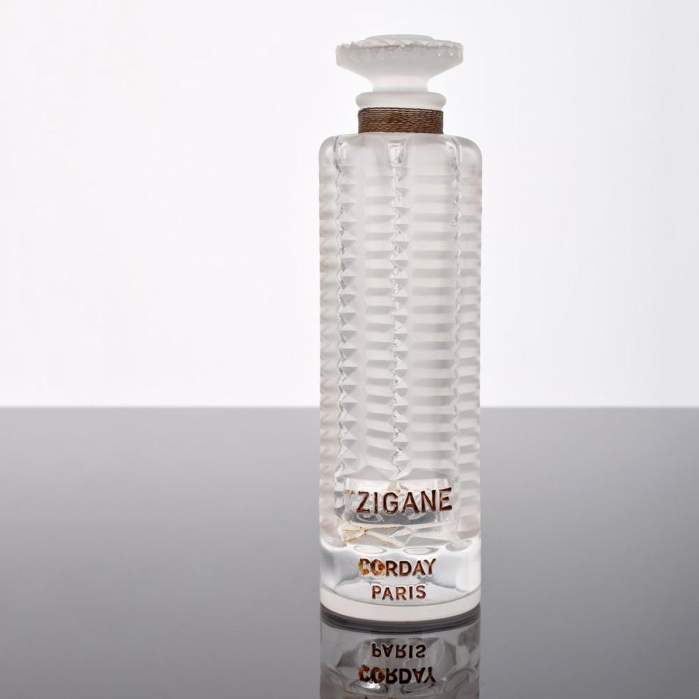 Clear glass perfume bottle with a faceted, ribbed texture and a white cap, labeled “ZIGANE” and “CORDAY PARIS.”