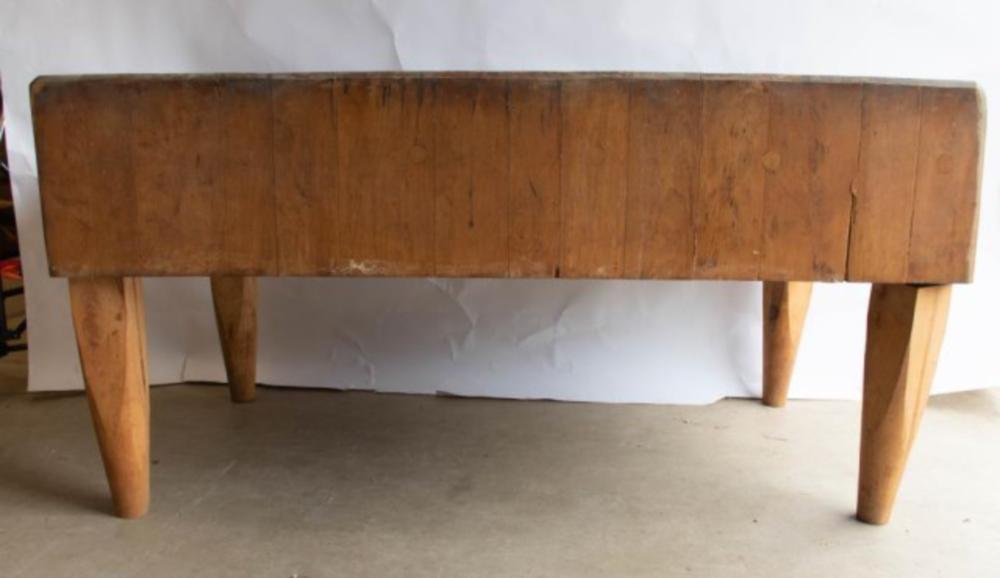 Rectangular wooden butcher block tabletop with four wooden legs, shown from the front against a light background.