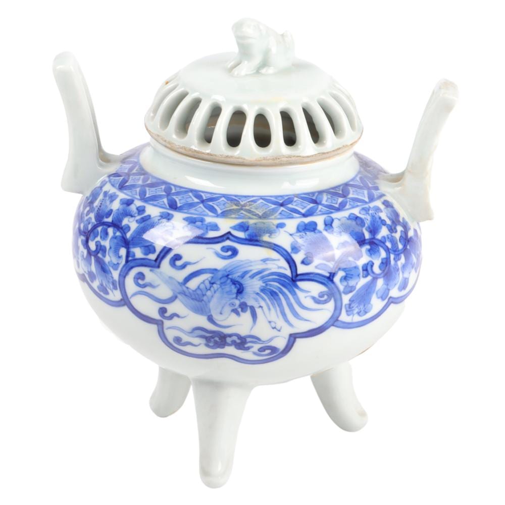 White and blue porcelain censer with pierced cover and lid handle, showing a blue-and-white dragon motif and two small foot stands.