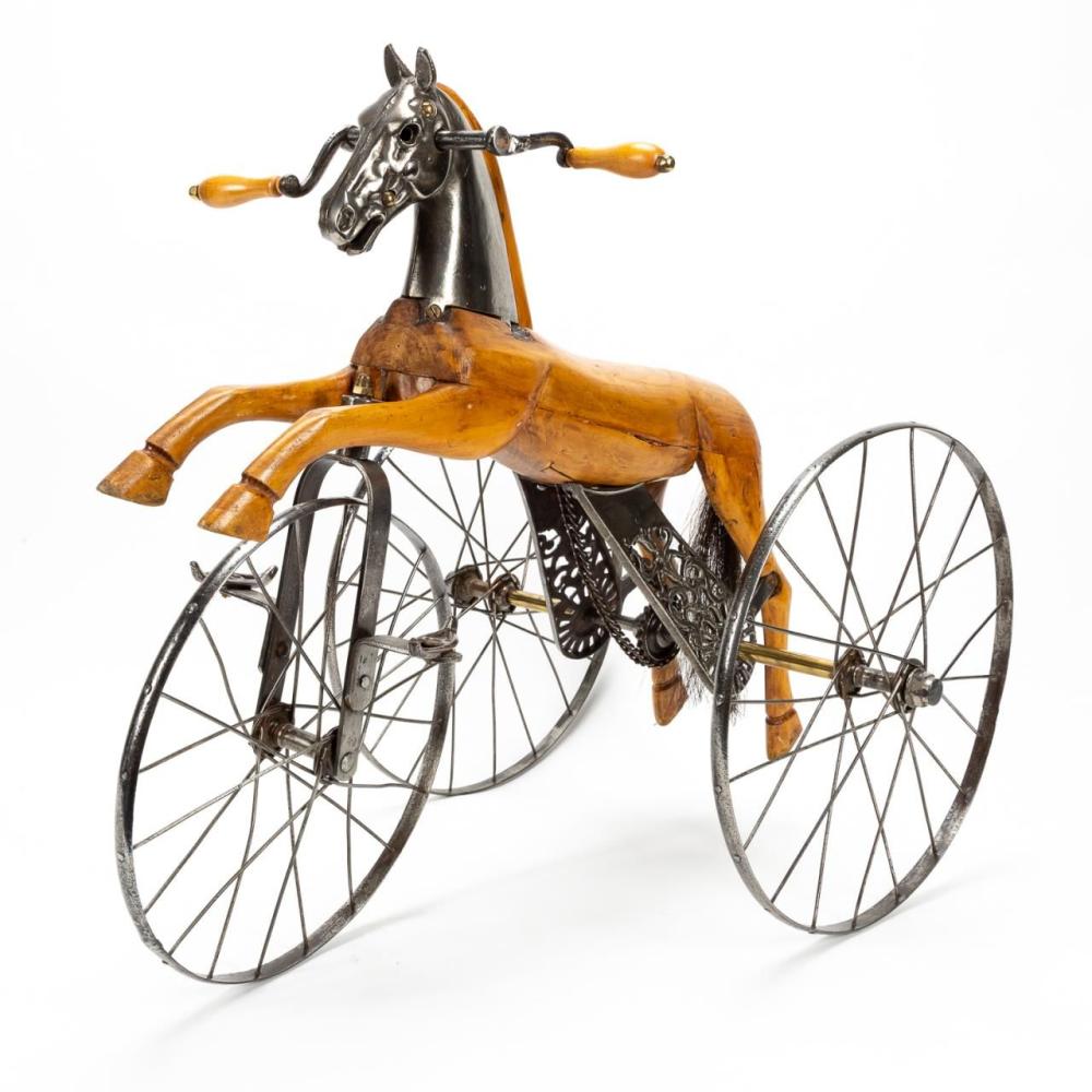 Toy horse velocipede tricycle with a rider figure and three spoked wheels, shown in a side view on a white background.