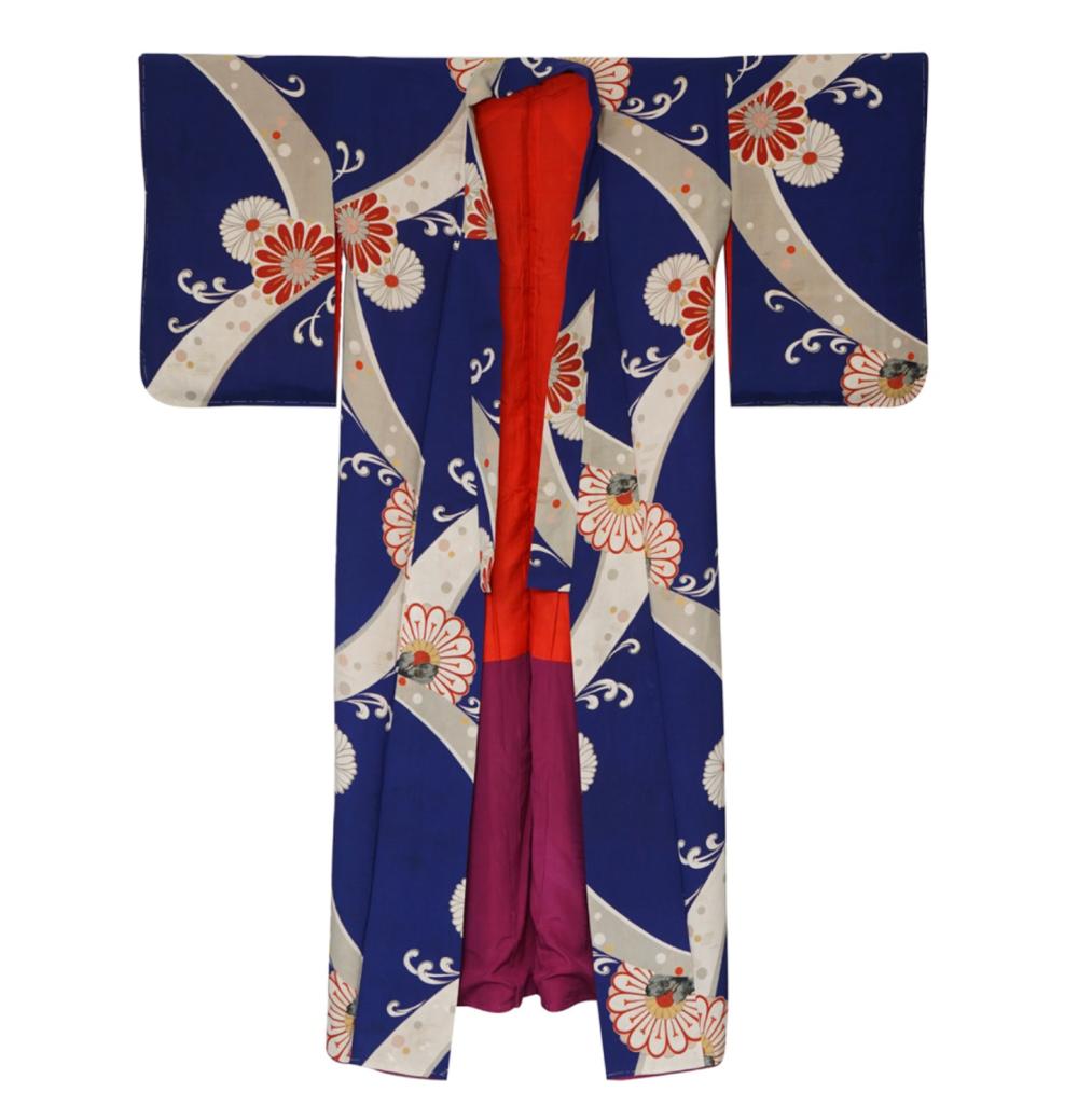 Folded Japanese-style kimono on a white background with navy blue, red, and cream fan and flower patterns.