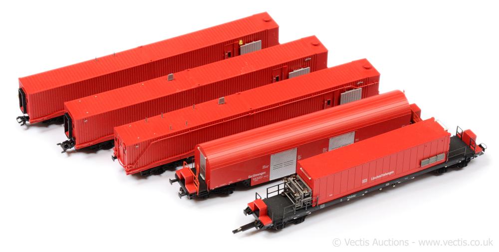 Three red and gray model rail freight cars on HO-style track, shown from a three-quarter angle on a white background.