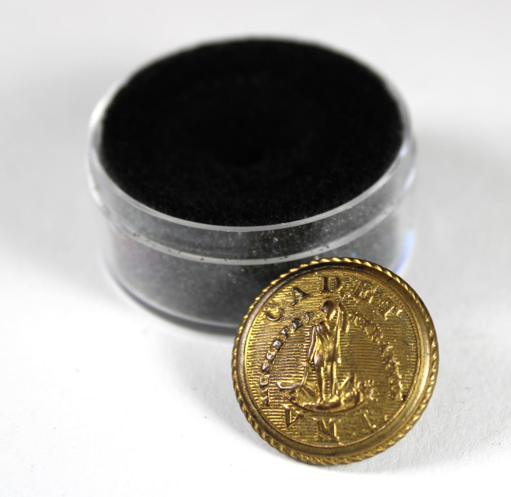 Brass military uniform button with an embossed figure standing in front of a circular laurel border, shown in a clear case with black felt backing.