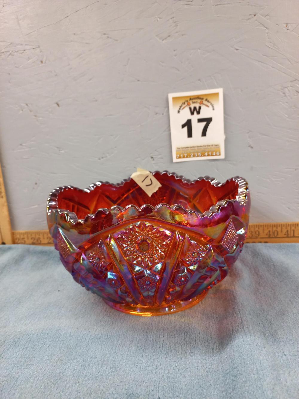 Red and purple carnival glass bowl with a fluted rim and faceted diamond pattern on the sides and base.