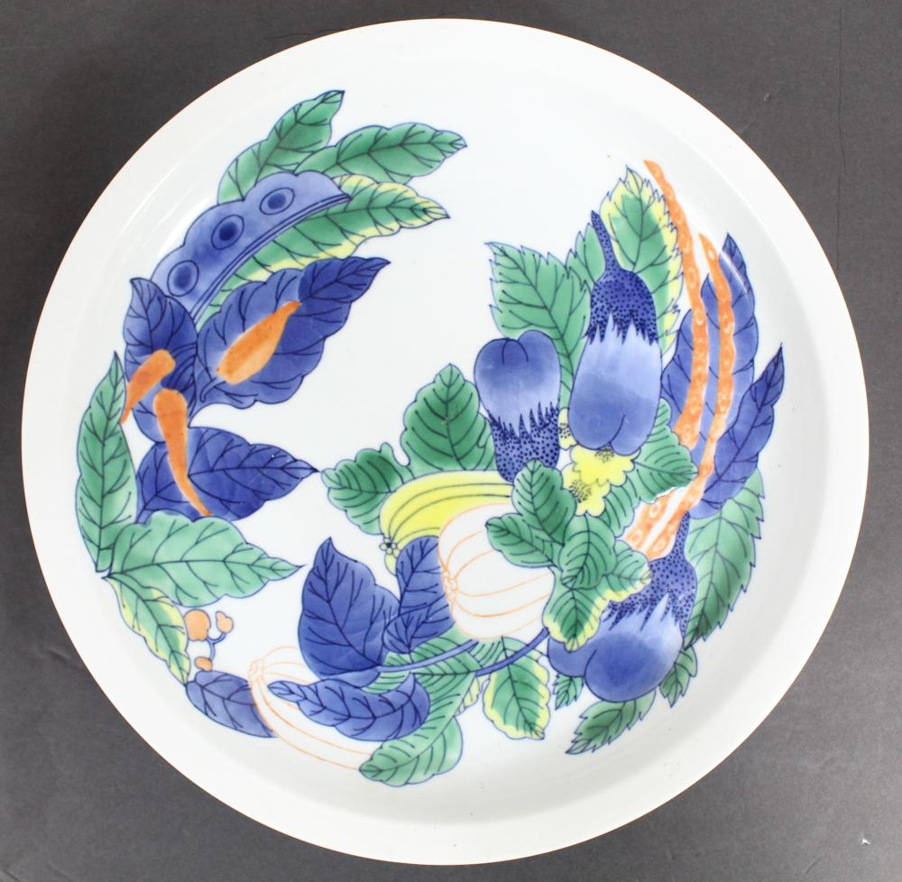 White Japanese porcelain footed plate decorated with blue and green leaves and purple berries with orange accents.