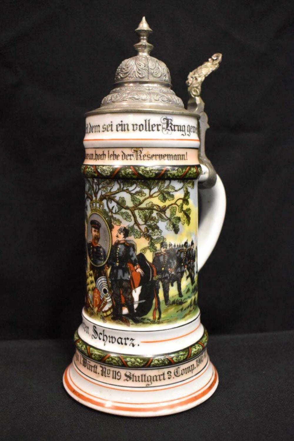 German-style beer stein with metal lid and handle, decorated with a military scene and floral bands