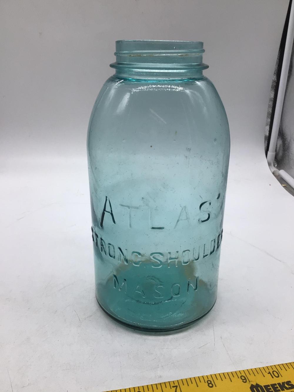Blue glass mason jar with a screw-top lid, photographed upright against a light background.