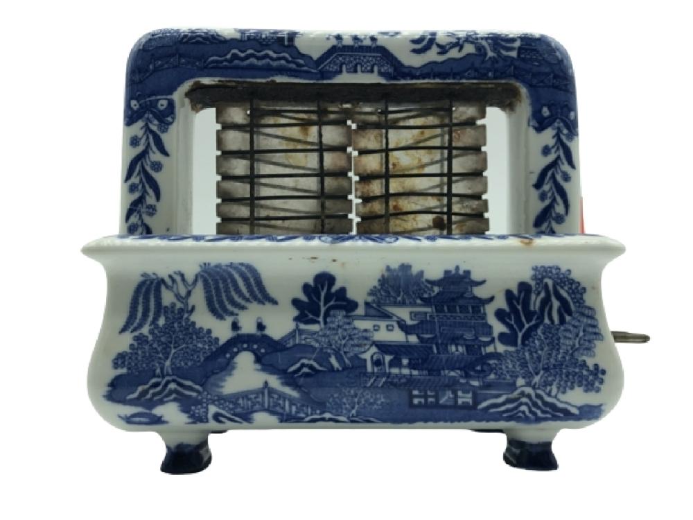 Antique-style blue and white porcelain toaster with a blue willow-pattern scene and open metal heating grille.