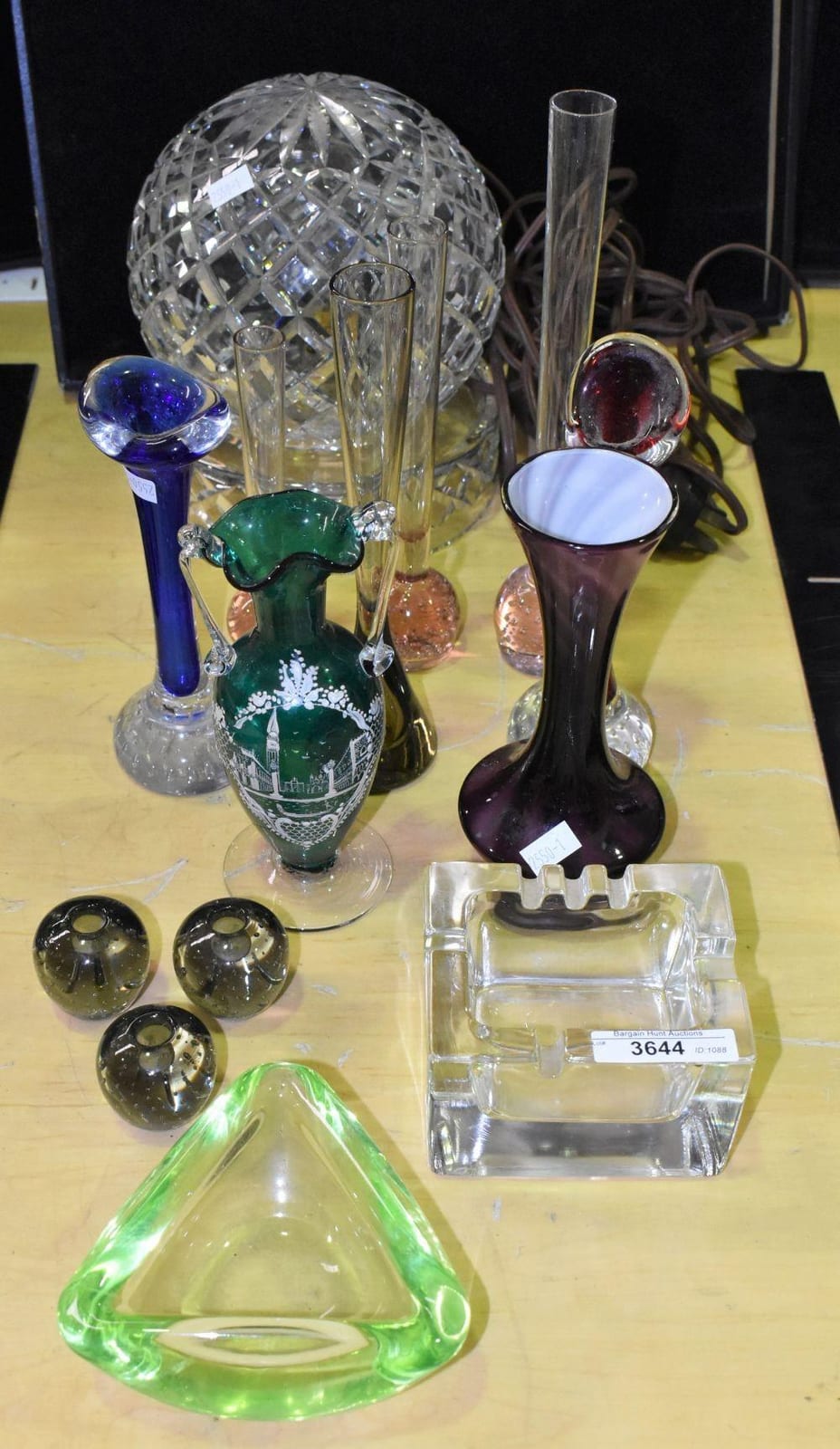 Quantity of assorted glassware including cut crystal lamp, antique green glass and enameled souvenir vase and assorted Art Glass vases, ashtrays and candle holders. sold by Bargain Hunt Auctions, lot 3644 — auction record photograph