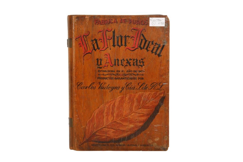 Wooden cigar box shaped like a book, with dark hinge hardware and printed text and leaf illustration on the cover.