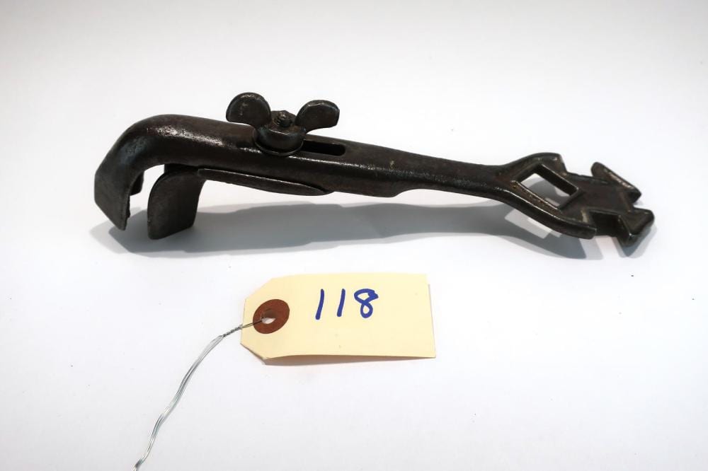 Black metal adjustable carriage buggy wrench lying on a white background, with an attached tag marked “118.”