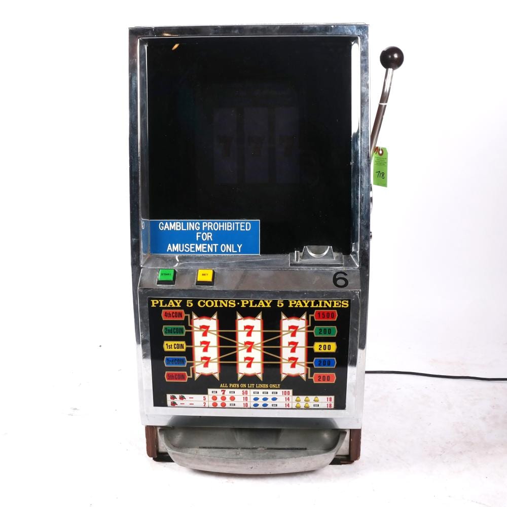 Vintage arcade-style slot machine with a black screen and a front panel showing red 7s and coin betting labels, viewed straight on.