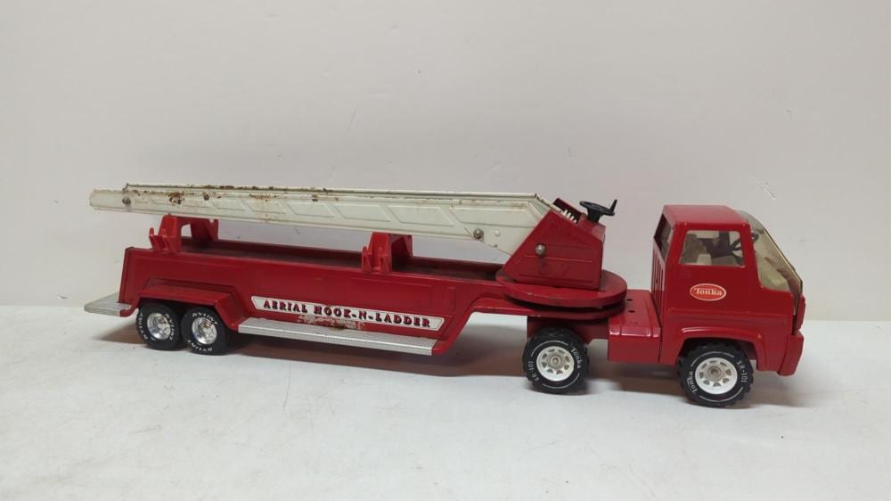 Red toy ladder truck with a white extended ladder and black wheels on a plain white background.