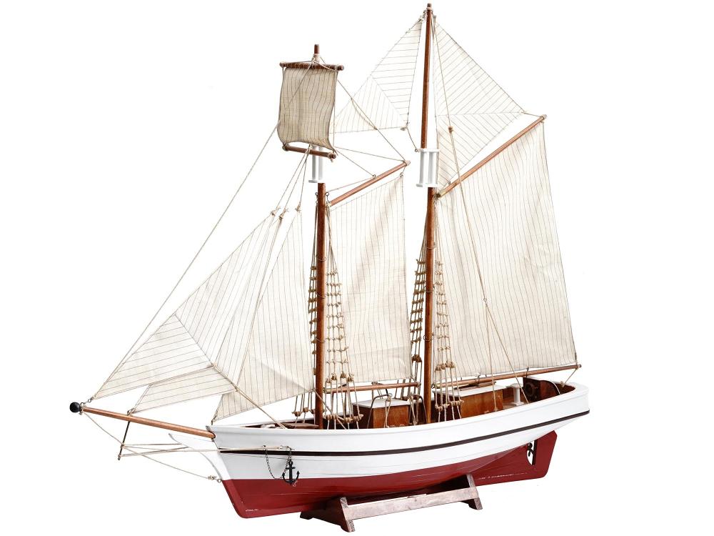 Wooden sailing ship model with multiple white sails and a red hull on a display stand.