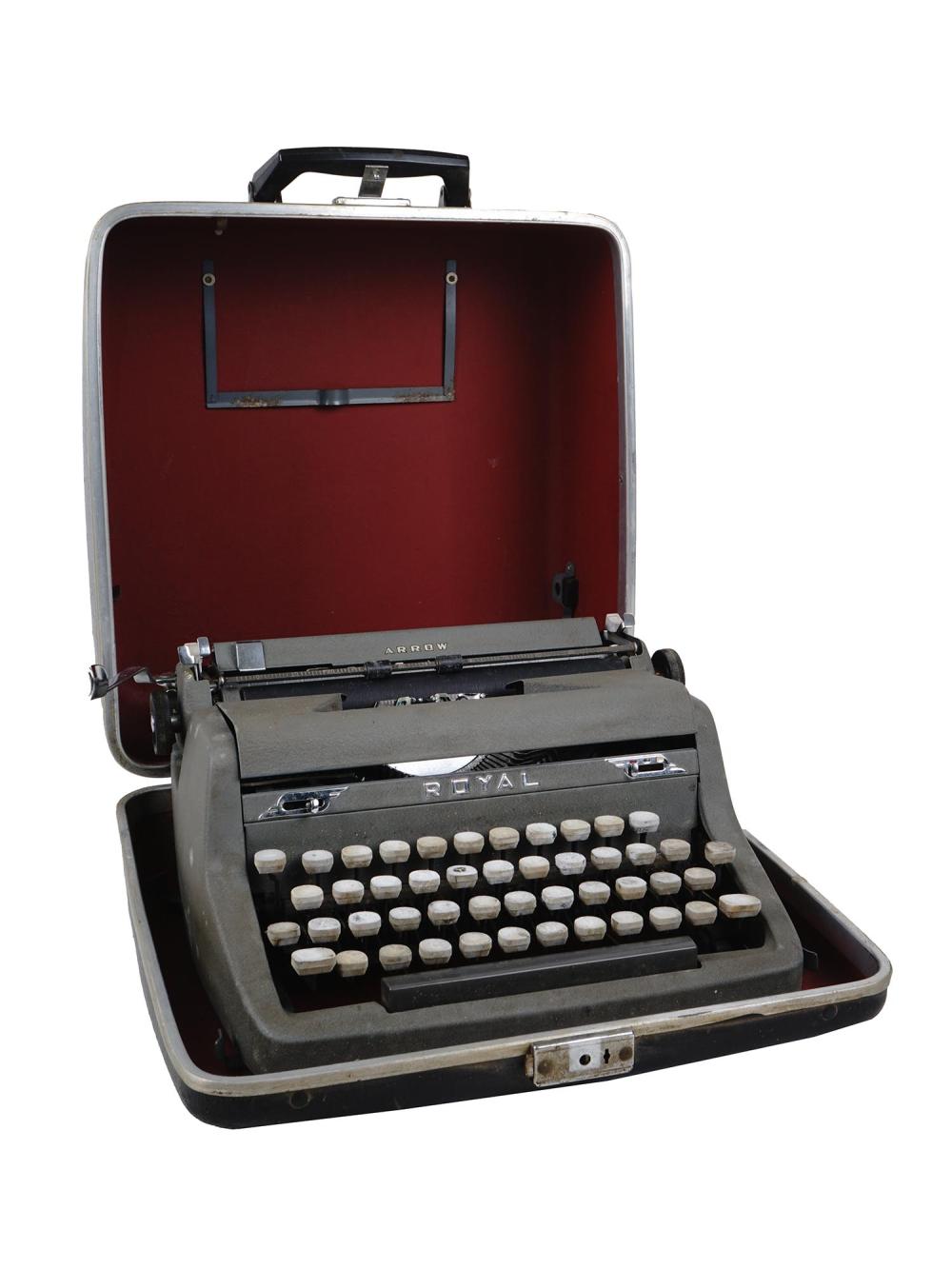 Vintage portable typewriter labeled “ROYAL” with keys and paper frame, shown inside an open metal case.