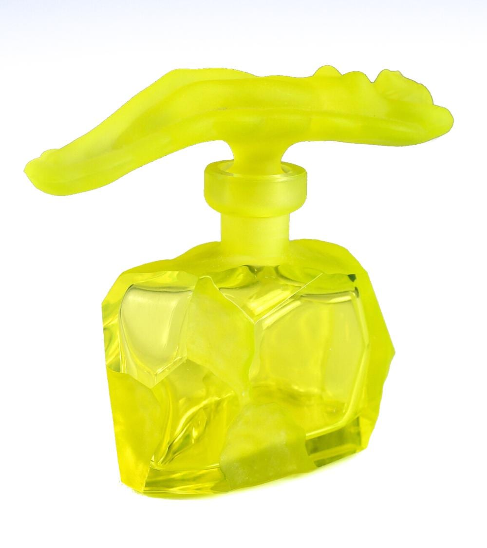 Bright yellow glass perfume bottle with a rounded stopper and sculpted animal-like handle, shown against a white background.