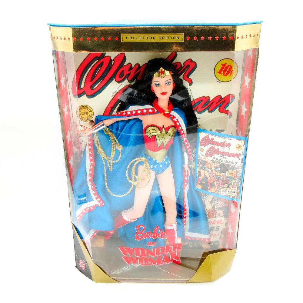In-box Barbie doll dressed as Wonder Woman in a blue star-spangled outfit with red-and-gold emblem and cape, shown in retail packaging.