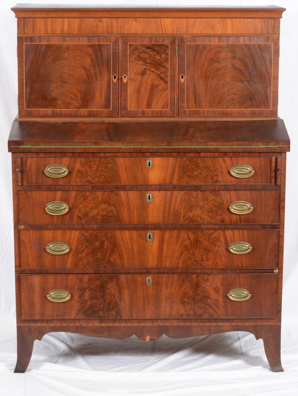 Auction comp thumbnail for Federal mahogany and inlaid secretary desk, circa 1820. Raised secretary top with three cabinet doors above a fold over writing desk on a case of four graduated drawers with flared French feet. Height 55in, Width 41in... (Tremont Auctions, Lot 298)