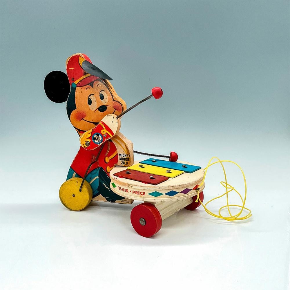 Vintage Mickey Mouse pull toy with a moving crank and string, featuring a character figure and a colorful board on wheels.