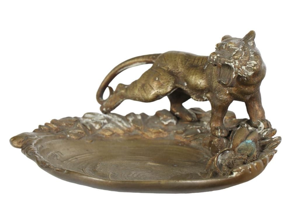 Bronze tiger figure standing on a circular dish with a molded leaf-like base and curled tail.