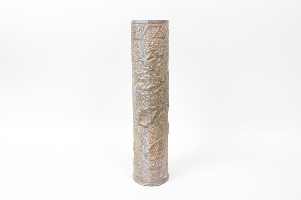 Tall hammered brass vase with embossed relief decoration, photographed on a white background.
